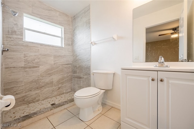 bathroom featuring a tile shower, toilet, tile patterned floors, and vanity