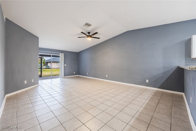 tiled empty room with ceiling fan and vaulted ceiling