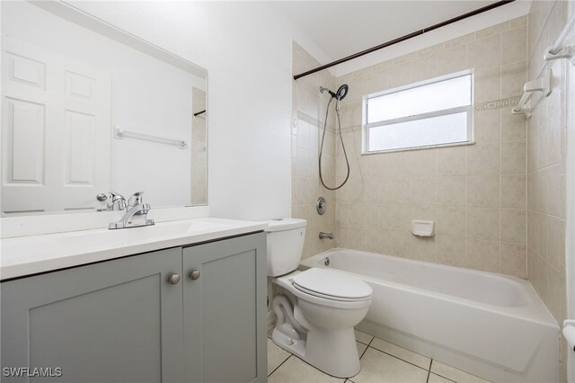 full bathroom with toilet, tile patterned flooring, tiled shower / bath, and vanity
