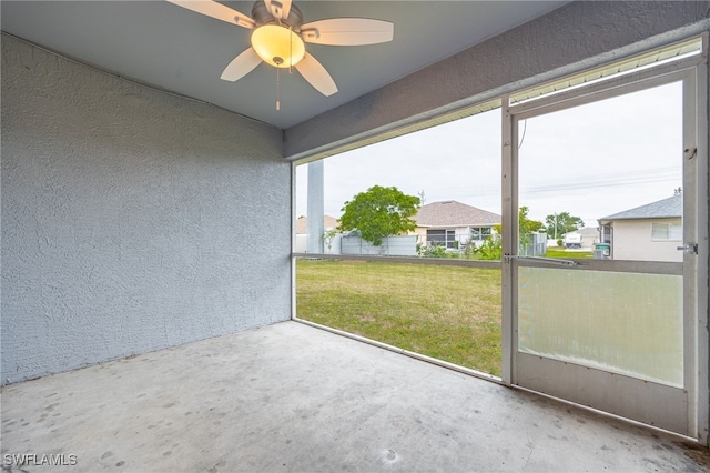 unfurnished sunroom with ceiling fan