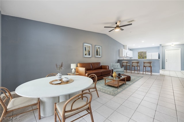 dining room with ceiling fan, light tile patterned floors, and lofted ceiling