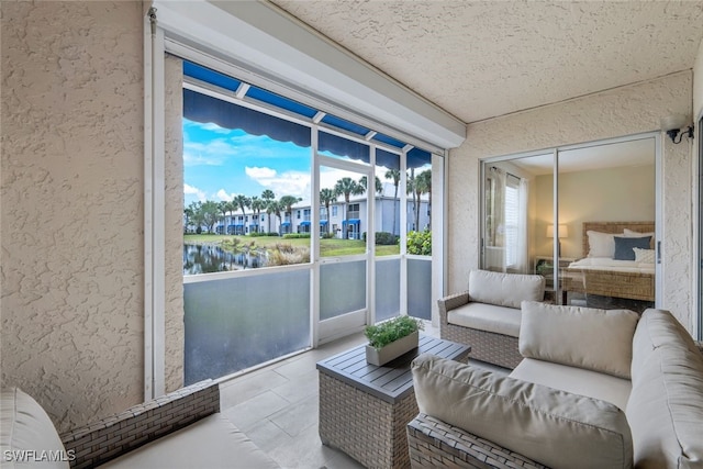 sunroom featuring a water view