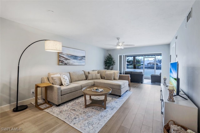 living room with ceiling fan and light hardwood / wood-style flooring