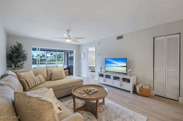 living room with ceiling fan and light hardwood / wood-style flooring