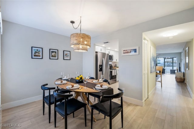 dining room with light hardwood / wood-style floors and a chandelier