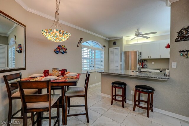 dining space with sink, light tile patterned floors, ornamental molding, and ceiling fan