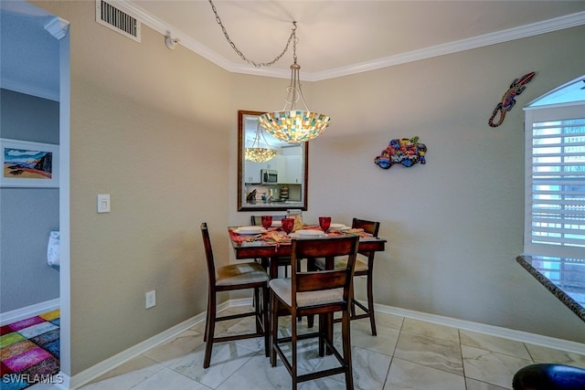 dining space featuring crown molding and a chandelier