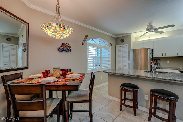 tiled dining room featuring sink, crown molding, and ceiling fan