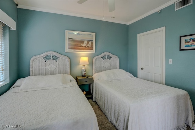 carpeted bedroom with ornamental molding and ceiling fan