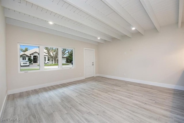 empty room with light wood-type flooring, wooden ceiling, beamed ceiling, and baseboards