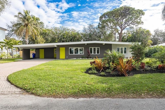 view of front of home with a carport, stucco siding, decorative driveway, and a front yard