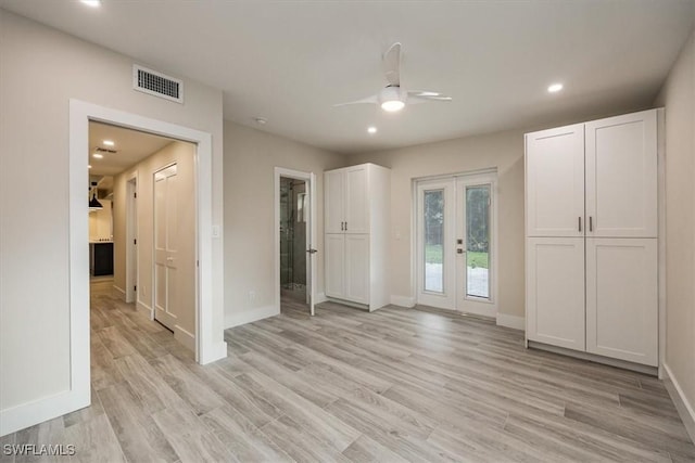 interior space with light wood-style floors, baseboards, visible vents, and french doors