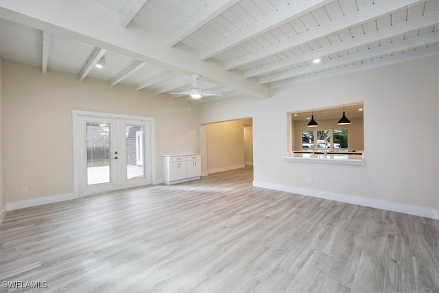 unfurnished living room featuring light wood finished floors, baseboards, a wealth of natural light, and french doors