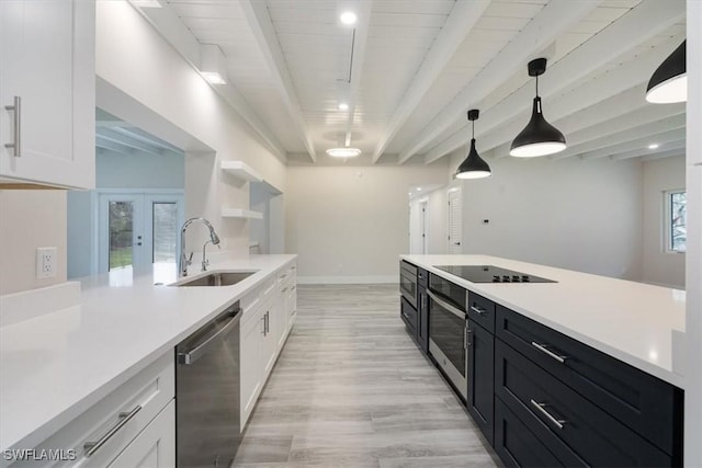 kitchen with stainless steel dishwasher, a sink, beam ceiling, and white cabinetry