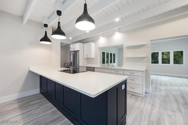 kitchen featuring stainless steel appliances, a peninsula, a sink, light countertops, and beamed ceiling