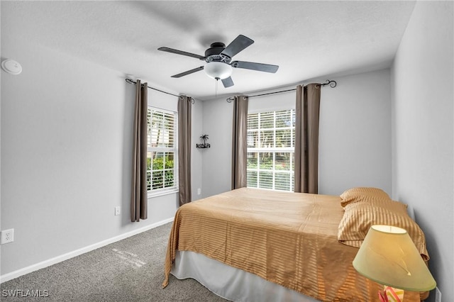 bedroom featuring ceiling fan, multiple windows, and carpet floors