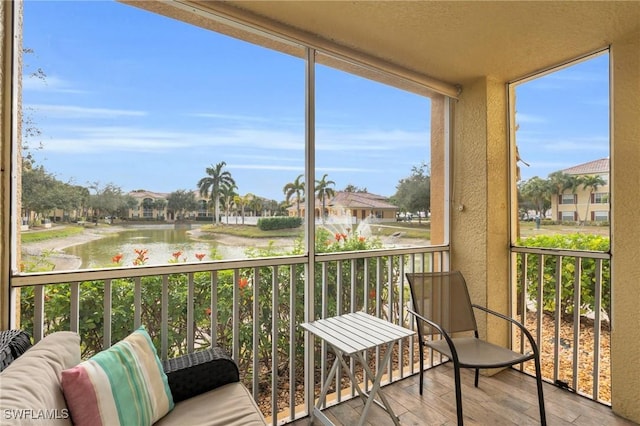 sunroom featuring a water view