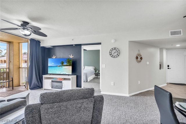 carpeted living room with ceiling fan