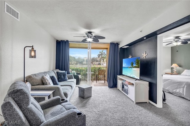 living room featuring a textured ceiling, ceiling fan, and carpet