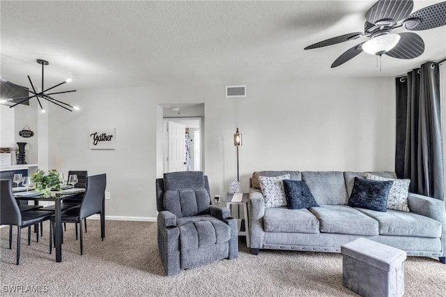 living room featuring carpet floors and ceiling fan with notable chandelier