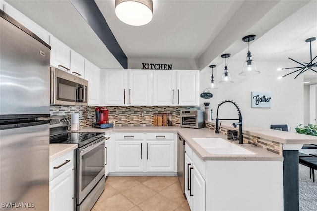 kitchen featuring white cabinets, kitchen peninsula, sink, and stainless steel appliances