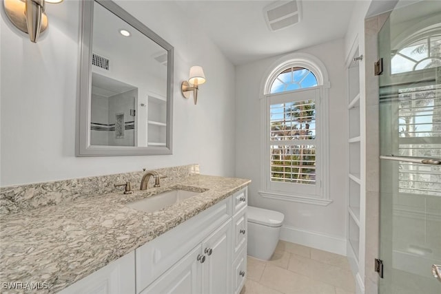 bathroom featuring toilet, tile patterned floors, an enclosed shower, and vanity