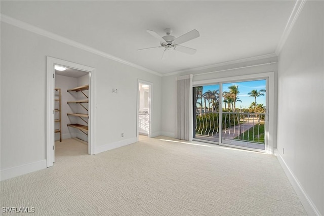 carpeted spare room featuring ceiling fan and crown molding