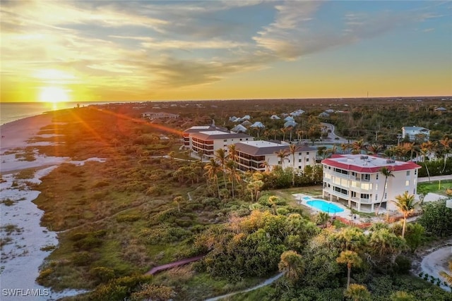 aerial view at dusk featuring a water view