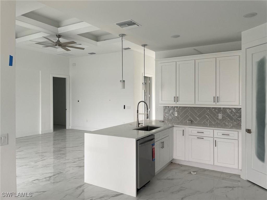 kitchen with white cabinetry, stainless steel dishwasher, kitchen peninsula, and coffered ceiling