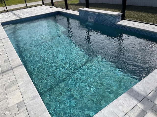 view of pool featuring pool water feature and glass enclosure