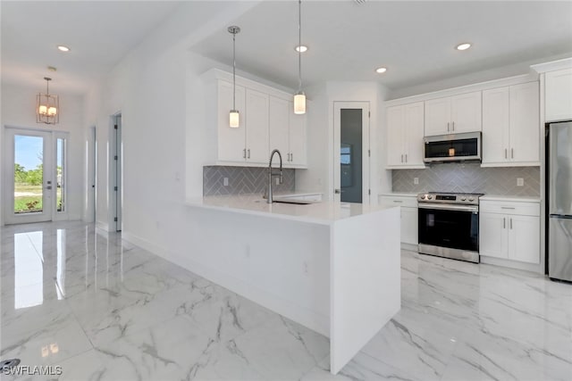 kitchen with a sink, marble finish floor, appliances with stainless steel finishes, and light countertops