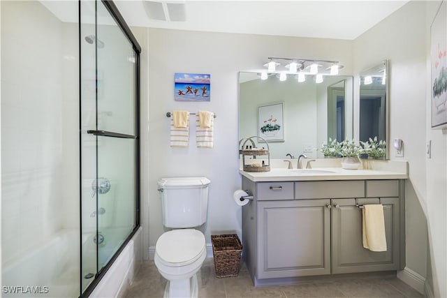 full bathroom with combined bath / shower with glass door, vanity, toilet, and tile patterned flooring