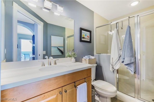 bathroom with an enclosed shower, vanity, and toilet