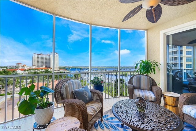 sunroom with a water view and ceiling fan