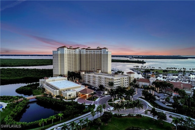 aerial view at dusk featuring a water view