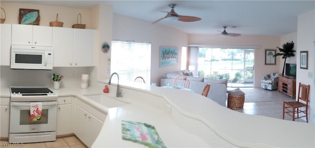 kitchen featuring white appliances, white cabinetry, sink, ceiling fan, and light tile patterned floors