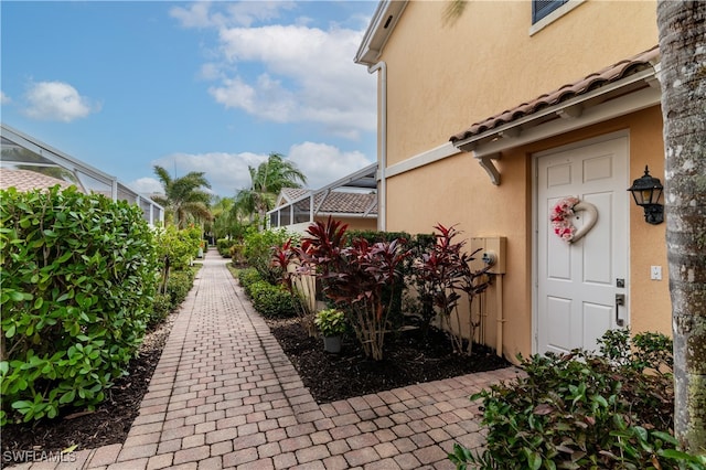 doorway to property featuring a tiled roof and stucco siding