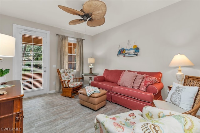 living room featuring wood finished floors, a ceiling fan, and baseboards