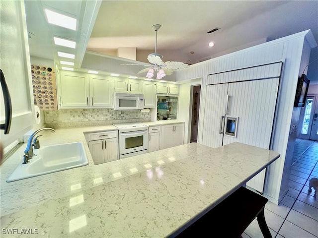 kitchen with decorative light fixtures, white appliances, white cabinetry, and sink