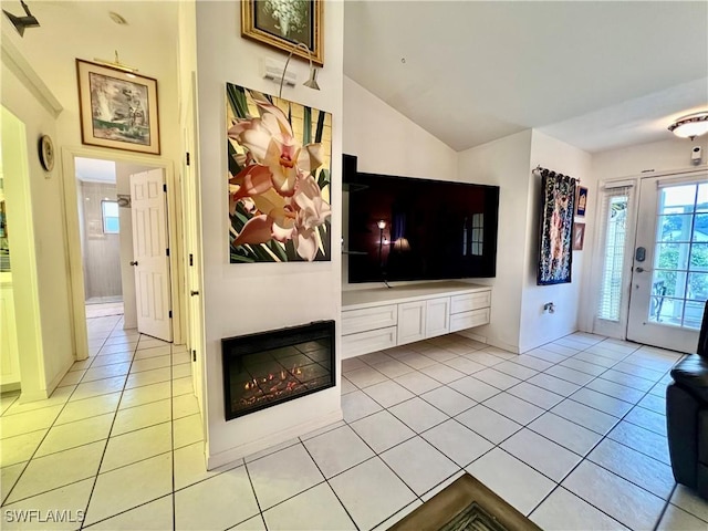 unfurnished living room with light tile patterned flooring and lofted ceiling