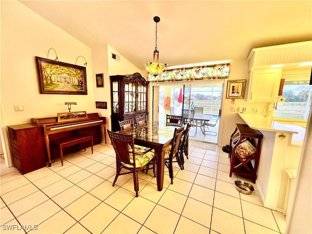 tiled dining room featuring lofted ceiling