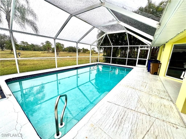 view of swimming pool with a patio, glass enclosure, and a lawn