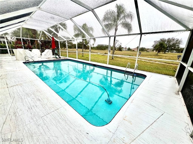 view of swimming pool featuring glass enclosure, a patio area, and a yard