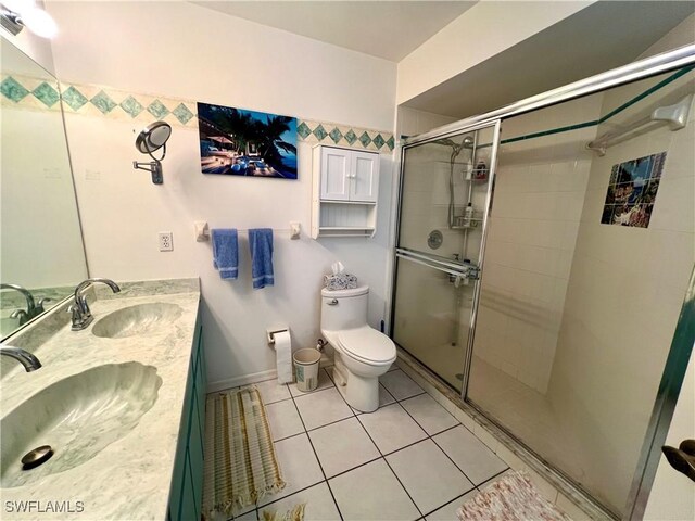 bathroom featuring vanity, toilet, tile patterned floors, and a shower with door