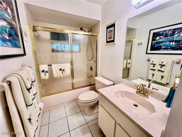 full bathroom with combined bath / shower with glass door, toilet, tile patterned floors, and vanity