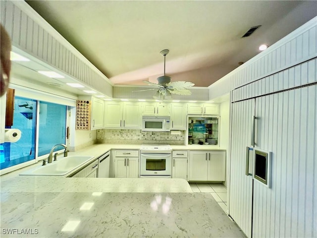 kitchen featuring white cabinetry, sink, white appliances, and lofted ceiling