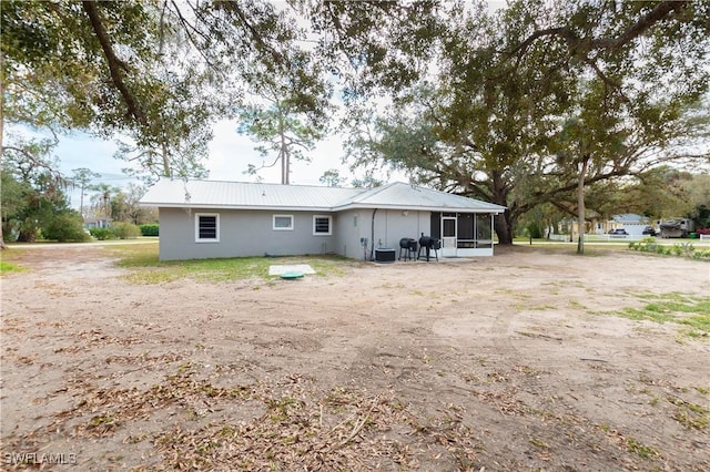 back of house featuring central AC unit and a sunroom