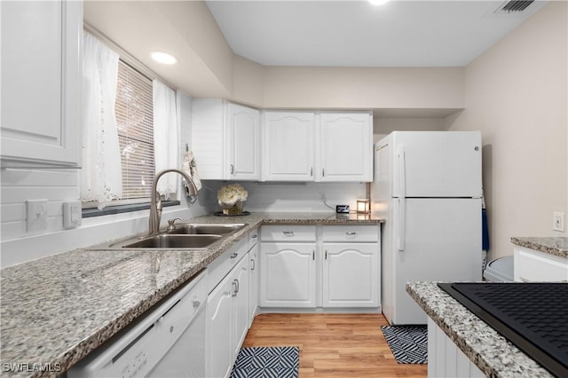 kitchen with white cabinetry, sink, white appliances, and light hardwood / wood-style flooring