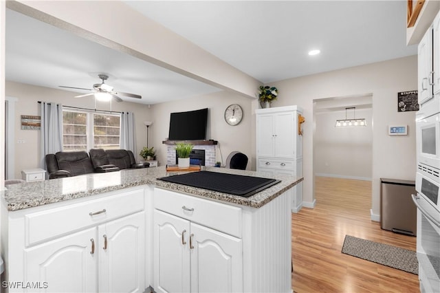 kitchen featuring white cabinets, black electric cooktop, and kitchen peninsula