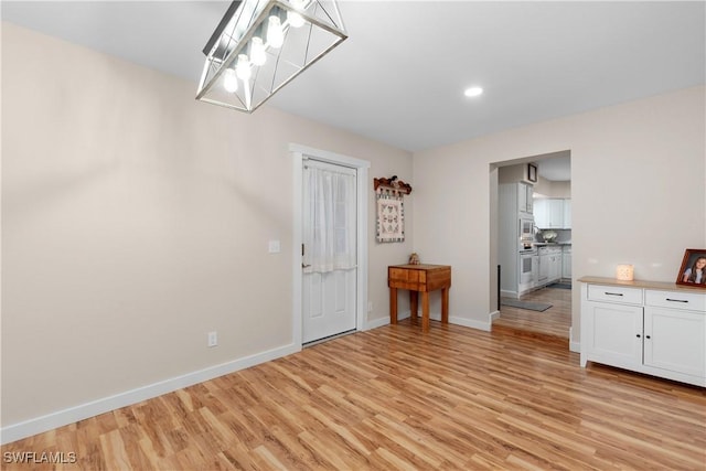 entryway with a notable chandelier and light wood-type flooring